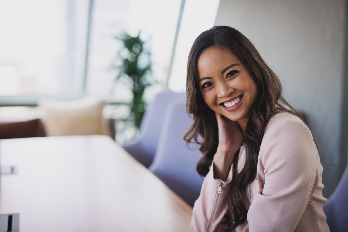 Modern corporate headshots, young business woman smiling in a bright conference room